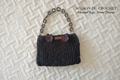 Borsa nera con catena su sfondo Maison du Crochet